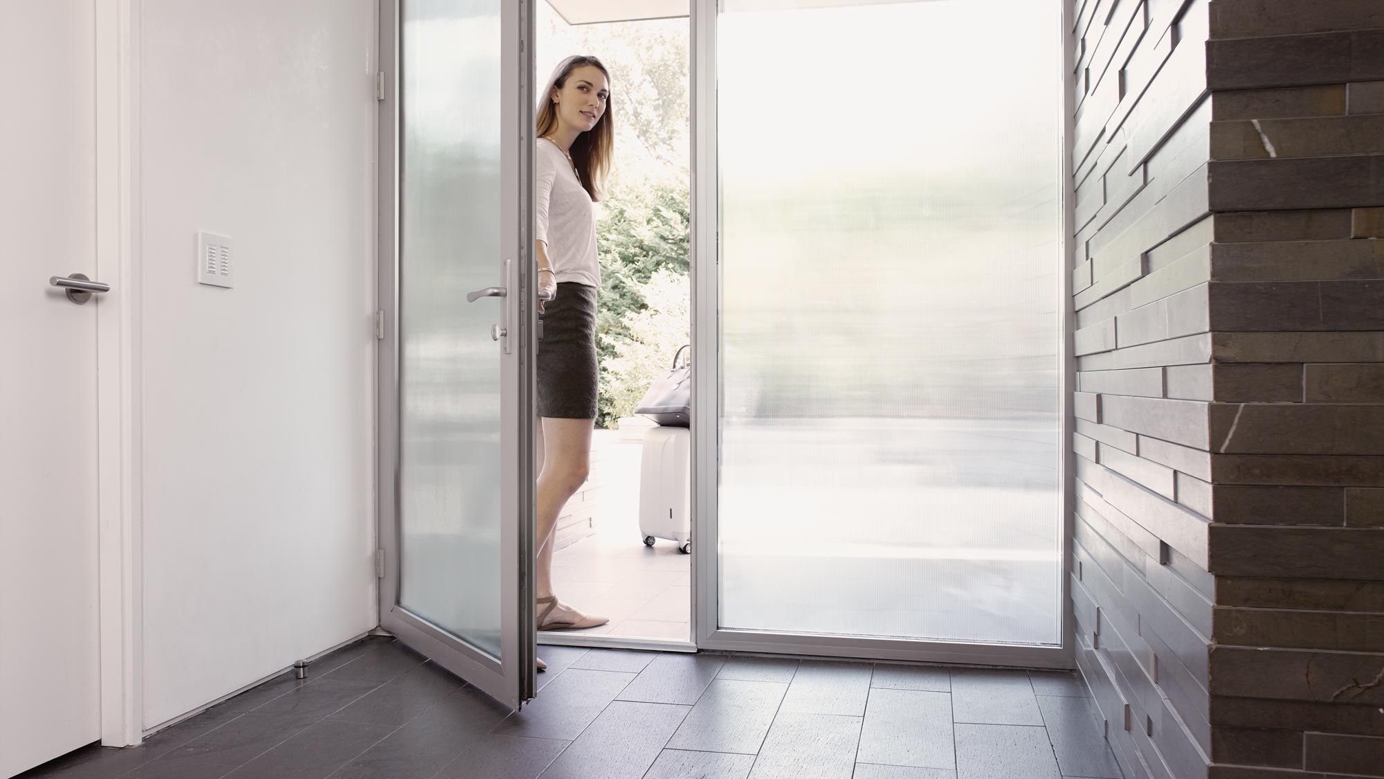 woman opening door into modern home